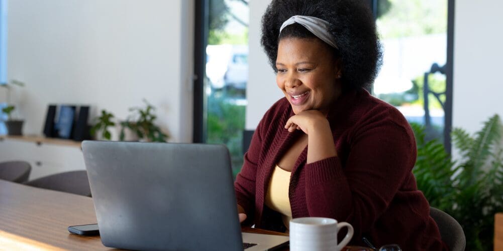 woman smiling looking at laptop screen