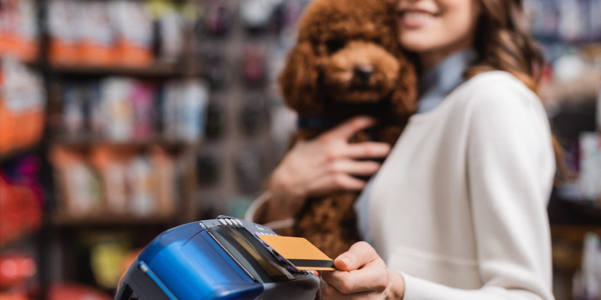 woman holding a dog and giving her card