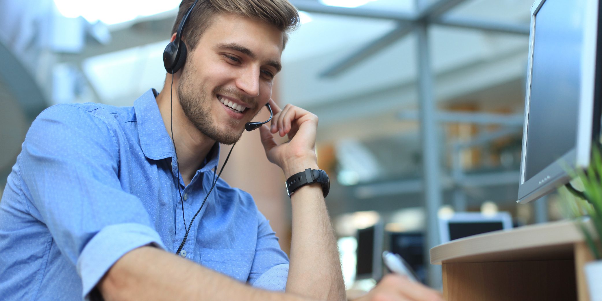 Smiling Friendly Young Businessman in a Call Center, Call Operator