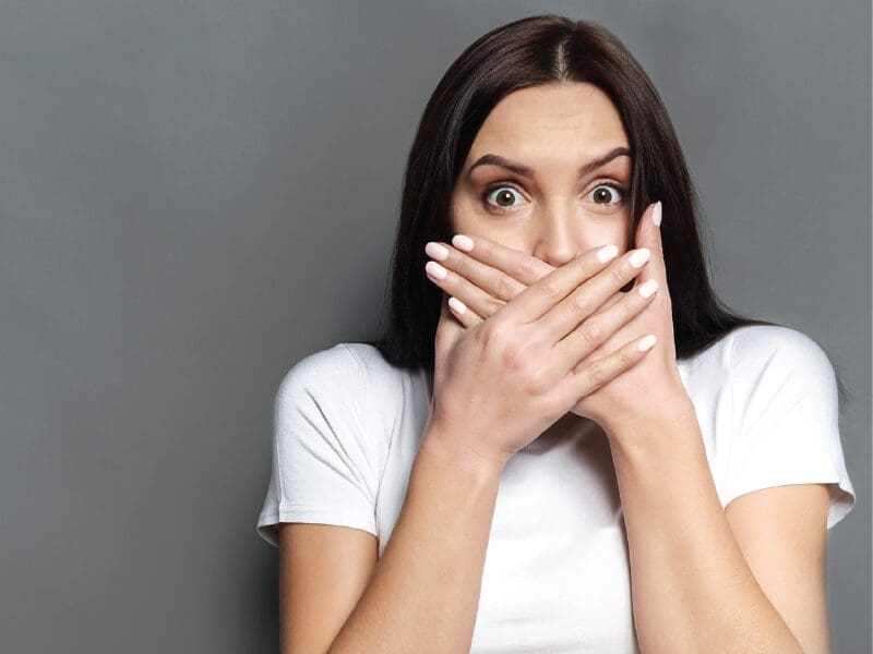 woman covering her mouth keeping a secret