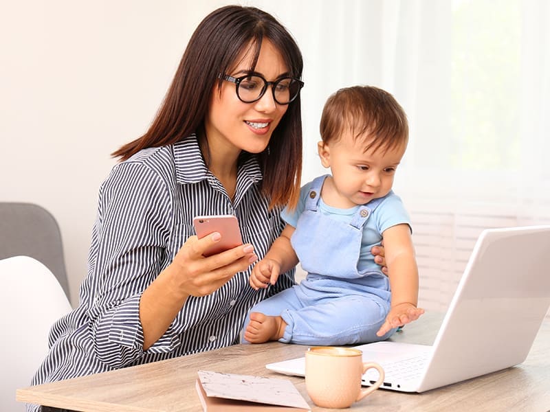 Mother with baby using phone to find provider