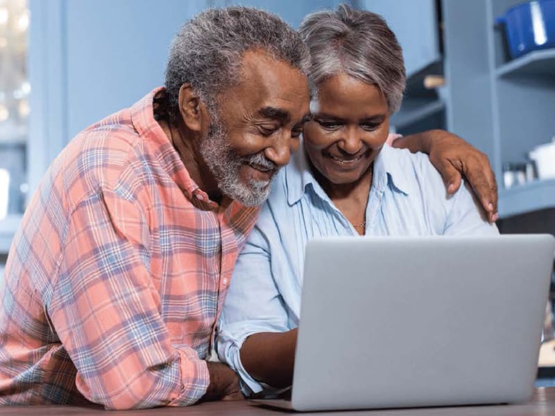 Retired married man and woman happily reviewing retirement plans
